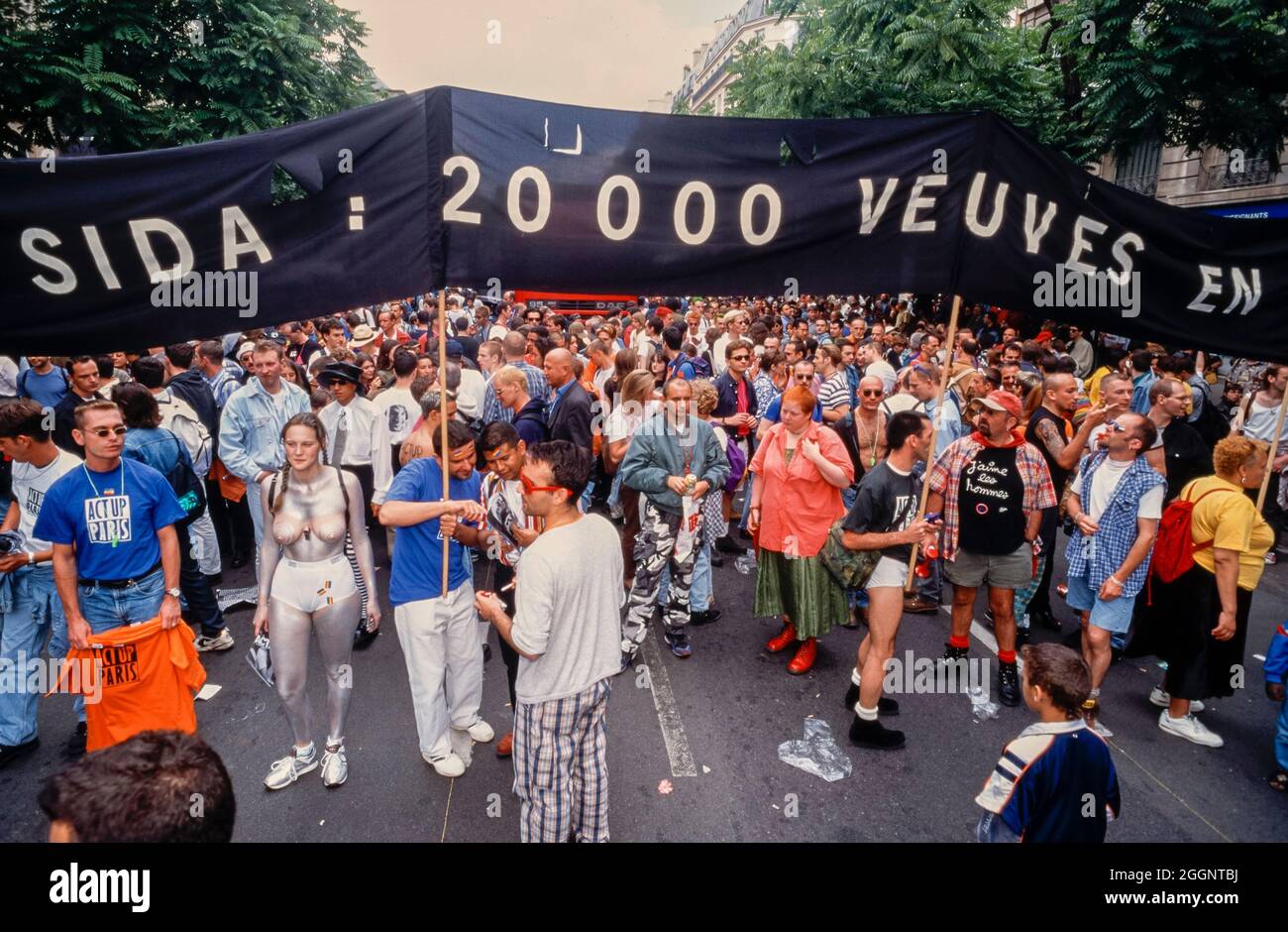 Crowd Protest of People, young lesbians and gay men, AIDS Activists of Act Up PAris Demonstrating on Street, 'Gay Pride' 1996, Queer activism, sign: 'AIDS: 20,000 Angry Widows' Stock Photo