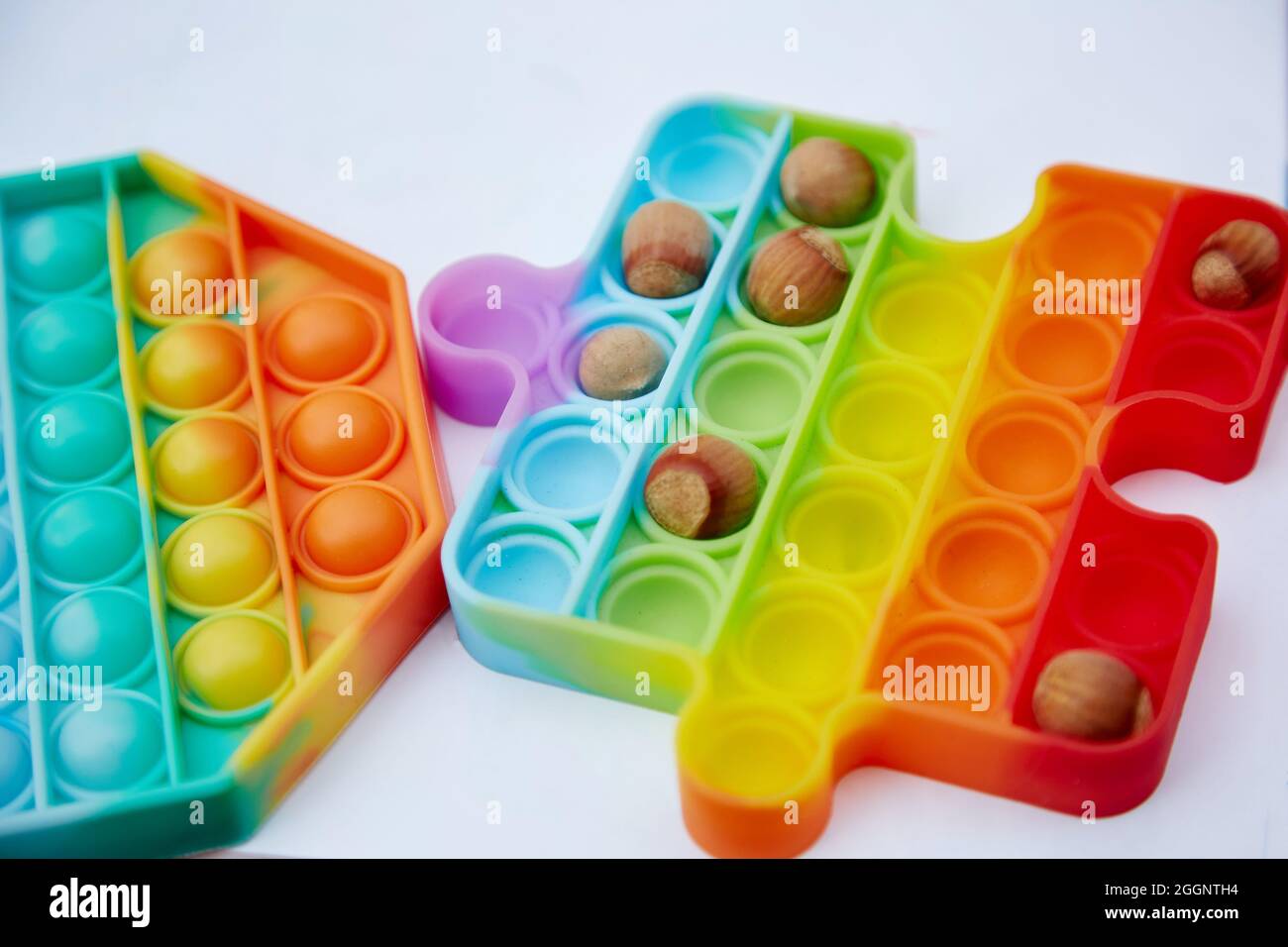 Pop it toy with hazel nuts. Invented games for motor skills development.  Rainbow sensory fidget push it. Close up High quality photo Stock Photo -  Alamy