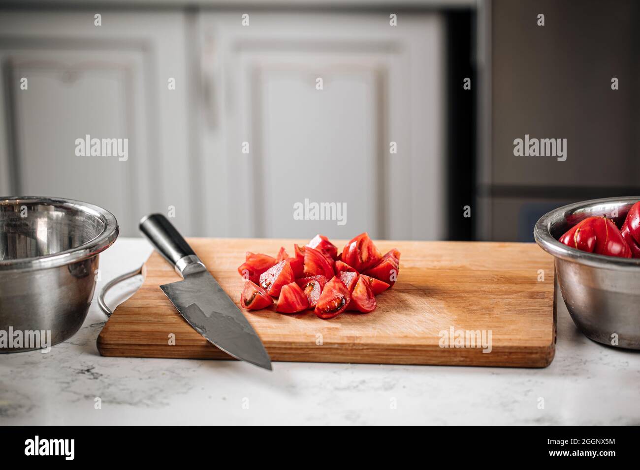 Chopped tomatoes on a kitchen desk with a knife Stock Photo - Alamy