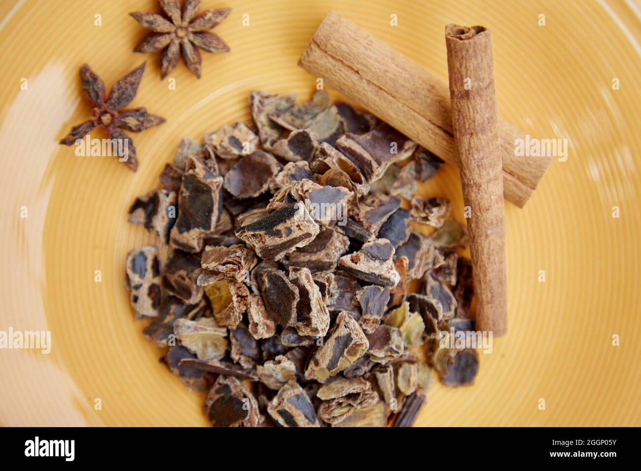 Plant-based alternative - natural carob close up. Organic antioxidants and protein. Decoration with cinnamon sticks and dried cloves. Top view. High quality photo Stock Photo