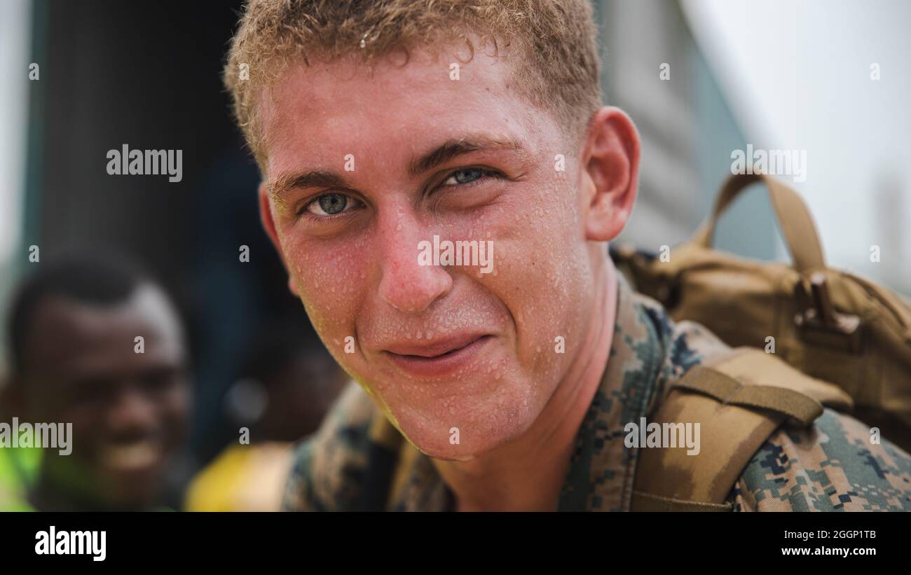 U.S. Marine Corps Lance Cpl. Derek Mensch, a native of Syracuse, N.Y. and a rifleman with 1st Battalion, 6th Marine Regiment, 2d Marine Division, helps offload boxes for redistribution in Port of Jeremie, Haiti, Aug. 31, 2021. “It was better than I expected it to be, getting to work alongside the Haitians was an amazing experience,” Mensch said. The Marines and sailors aboard the USS Arlington (LPD 24) have been working in support of Joint Task Force-Haiti for a humanitarian assistance and disaster relief mission. “Being there and being able to help thousands of people was remarkable. Smiling Stock Photo