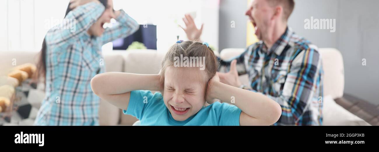 Little girl covering her ears with her hands against background of