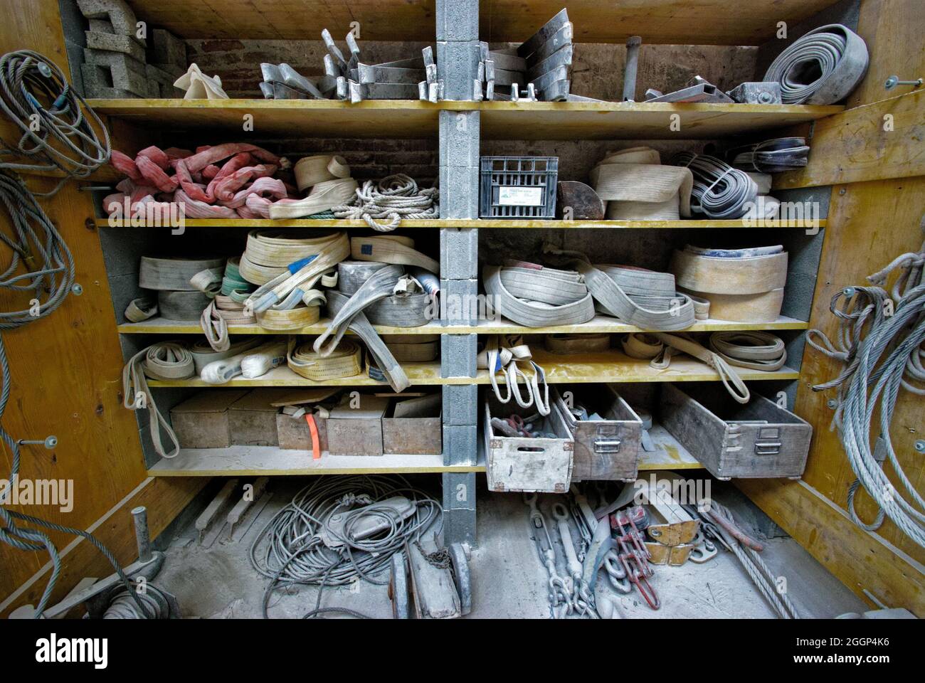 View of wooden shelves of rusty old tools and metal draws and wires at