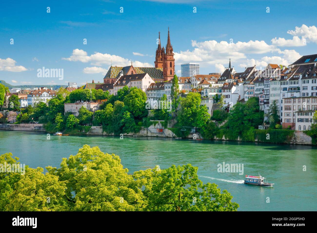 Blick auf das Basler Münster inmitten der Basler Altsatdt mit dem türkis farbenen Rhein Fluss im  Vordergrund Stock Photo