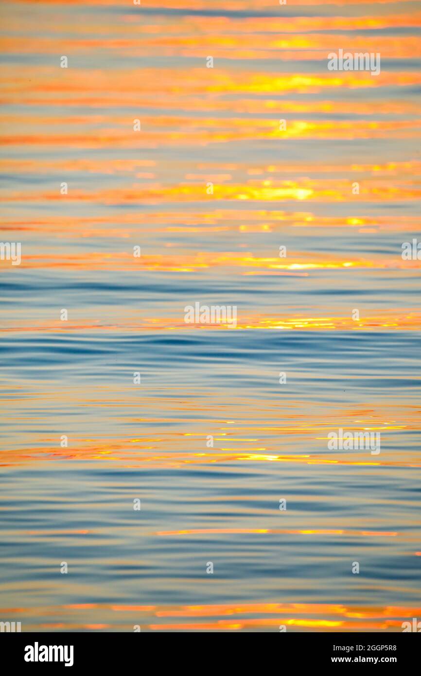 Sonnenstrahlen reflektieren auf Wasseroberfläche vom Bodensee bei Sonnenaufgang und bilden ein abstraktes Muster Stock Photo
