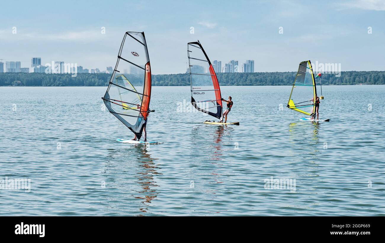 Windsurfing training. Several children floating on boards with sail on