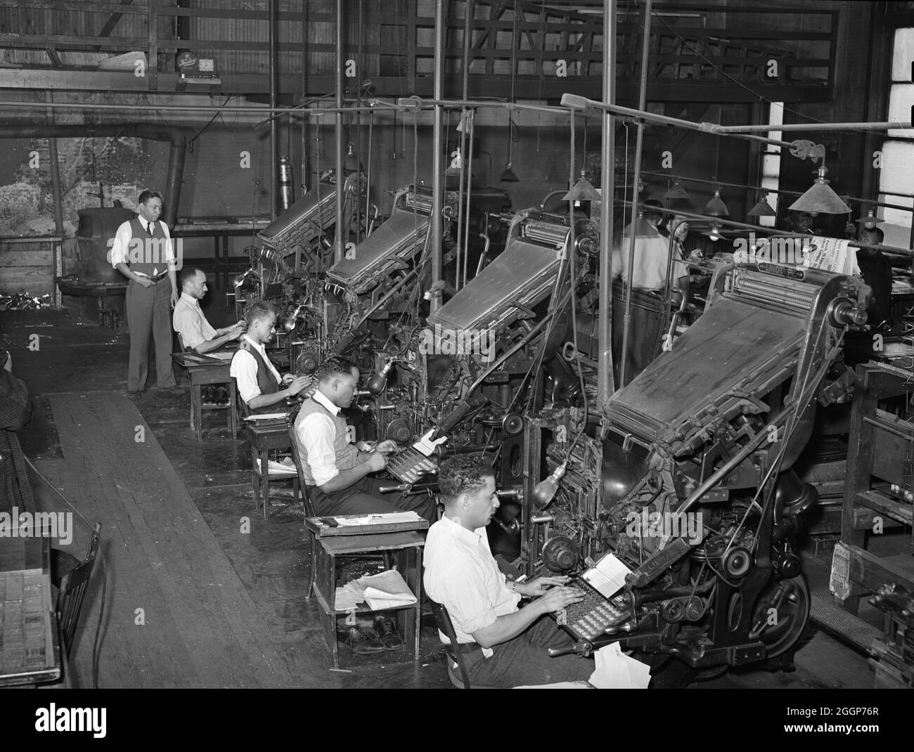 Linotype operators of the Chicago Defender, a Black newspaper, in Chicago, Illinois, 1941. Photographed by Russell Lee. Stock Photo