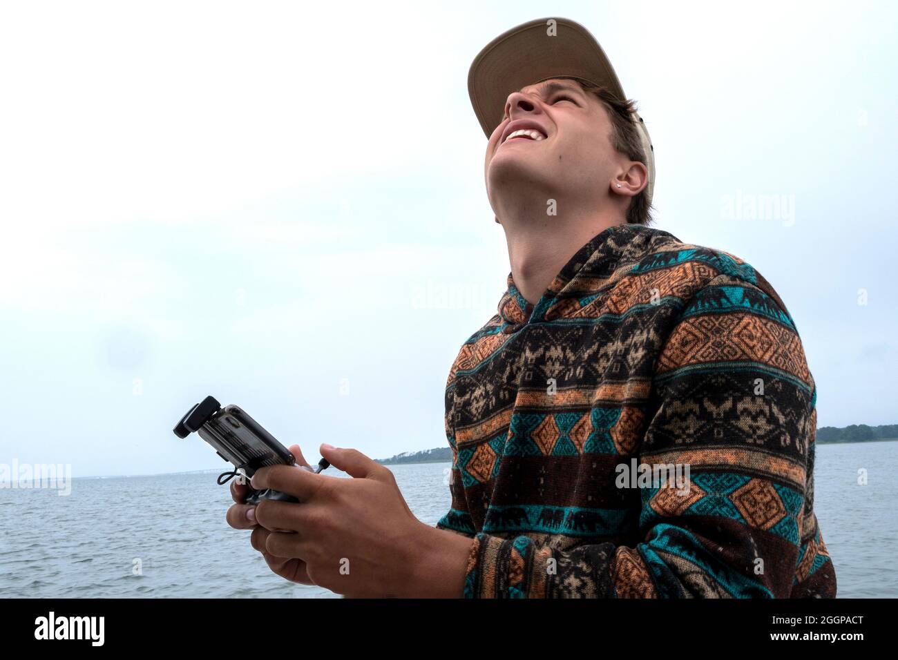 Young man operating aerial photography drone on a small boat Stock Photo