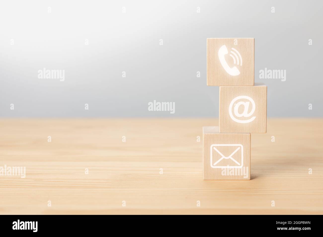 contact us icon phone, email, mail on wood cube, customer service and support. Wooden cubes with symbol telephone, email, address. Website page contac Stock Photo