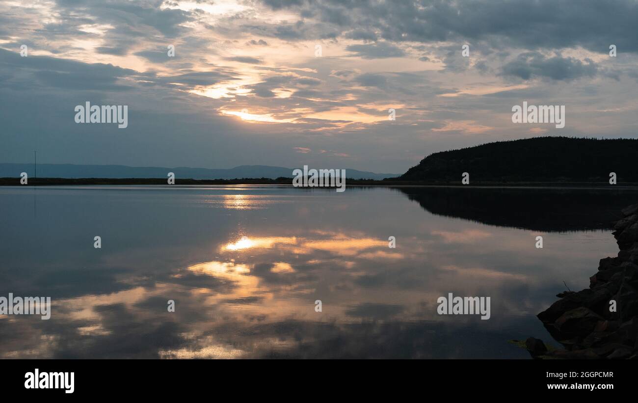 Beautiful sunset sky reflecting on a calm sea Stock Photo - Alamy