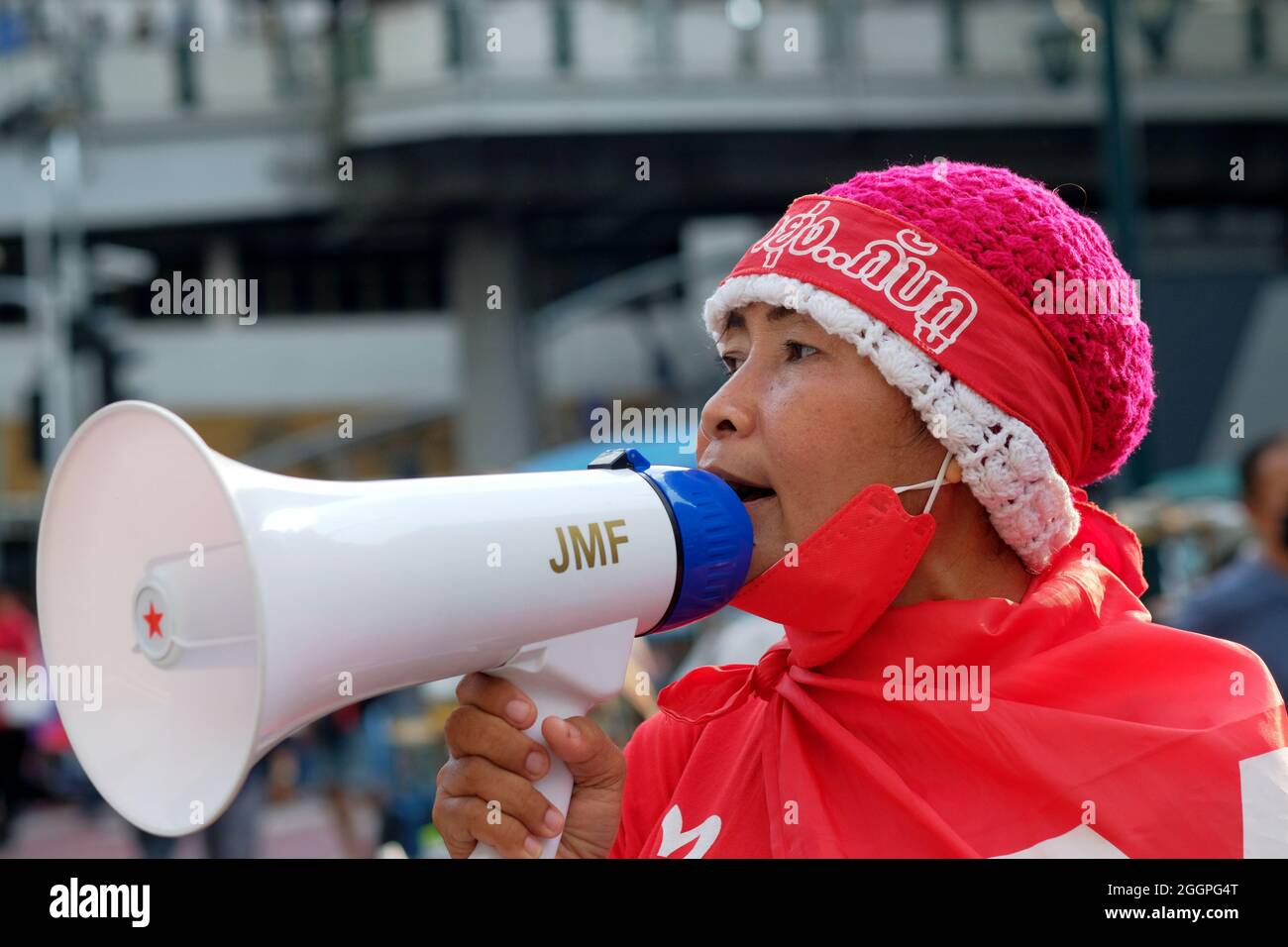 Bangkok, Thailand, 2 September 2021, a female supporter of the United Front for Democracy Against Dictatorship (UDD) shouts with a megaphone alongside other protestors to demand the resignation of Thailand's Prime Minister General Prayut Chan-ocha. Today's protest closed the north-south carriageways of the Asoke road junction in central Bangkok, and restricted traffic along the Sukhumvit Road. Today's event was part of an on-going series of protests across the country to voice disaffection with the current government's performance during the COVID pandemic. Stock Photo