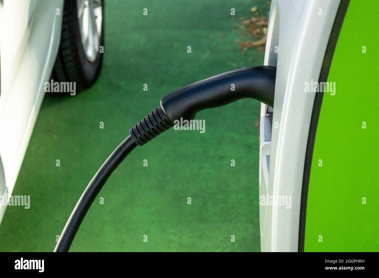 Car recharges its electric batteries inside a private garage with its