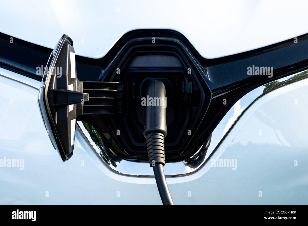 Car recharges its electric batteries inside a private garage with its