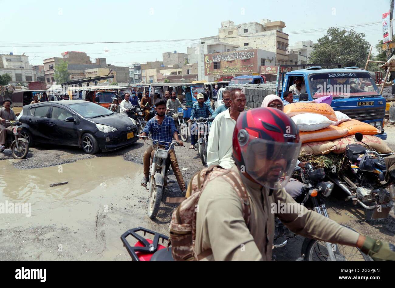 Commuters are facing difficulties in transportation due to stagnant sewerage water due to poor sewerage system and wreckage condition of new constructed road, creating problems for residents, showing negligence of concerned authorities, located on 4-K roundabout Surjani Town area of Karachi on Thursday, September 02, 2021. Stock Photo
