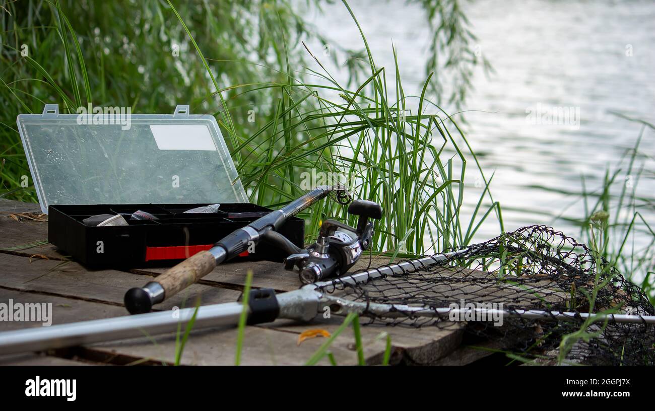 https://c8.alamy.com/comp/2GGPJ7X/fishing-tackle-on-the-river-bank-bait-rod-spinning-rod-fish-nature-selective-focus-2GGPJ7X.jpg