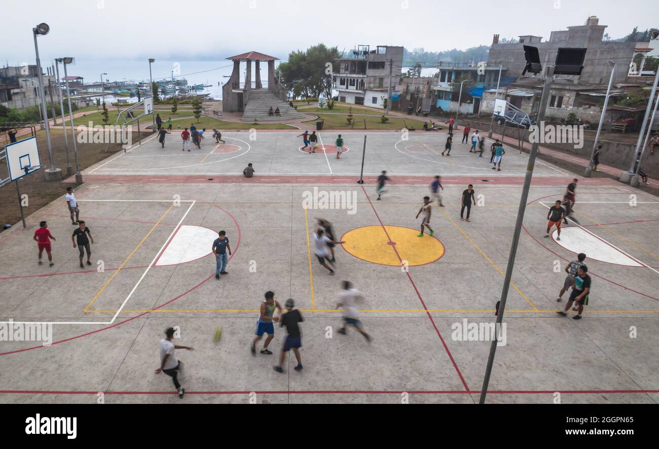 Santiago Atitlan, Guatemala - 29 March 2018: Local men playing football and basketball on the concrete sports field along the lake in Santiago Atitlan Stock Photo