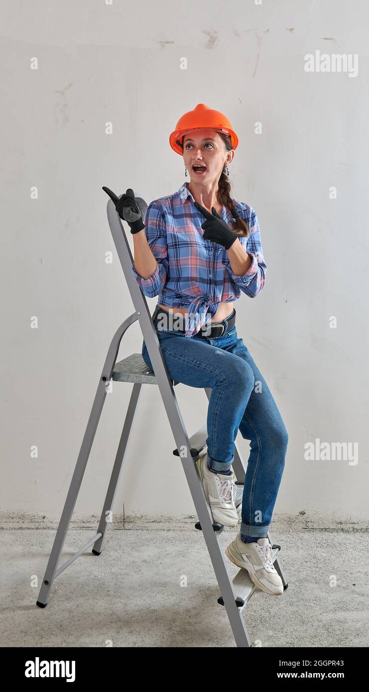 in black gloves and a helmet, a joyful repairwoman Stock Photo Alamy