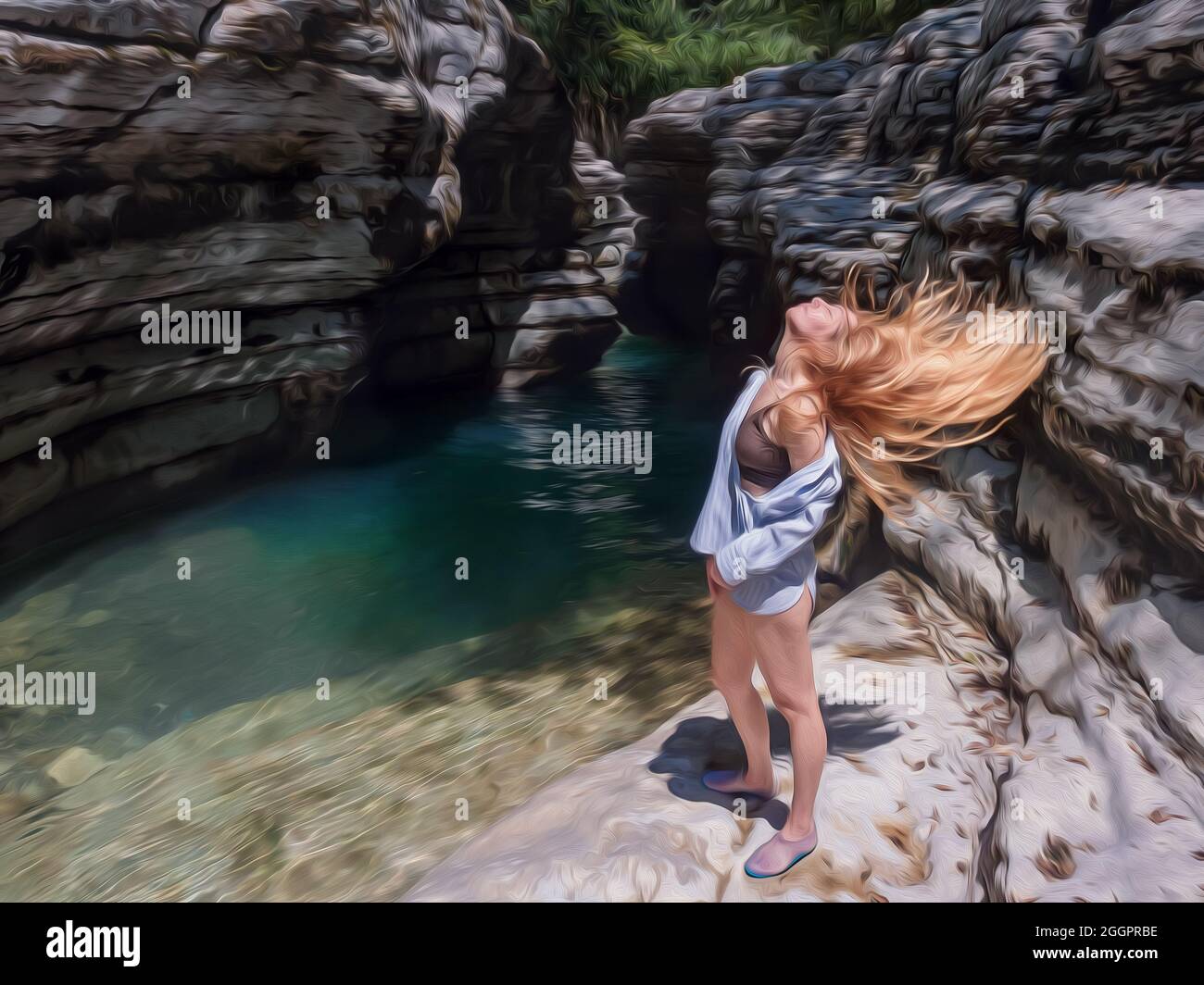 A girl throws her hair back standing on a rocky bank near a clear river