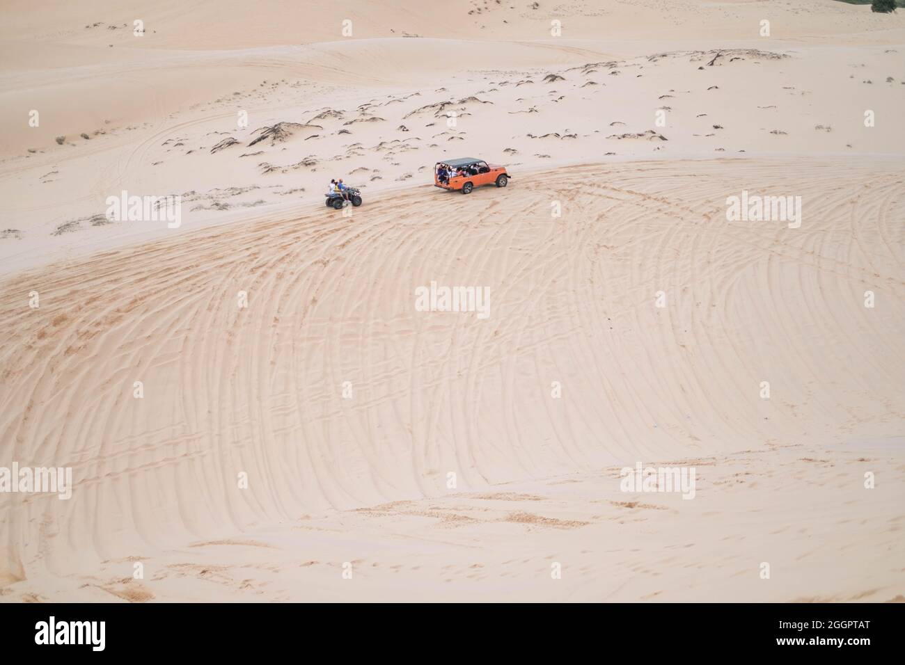 Picturesque view of big car driving on sandy dunes and tire tracks on sand on sunny day during summer vacation. Sand dunes. Hight quality photo. Stock Photo