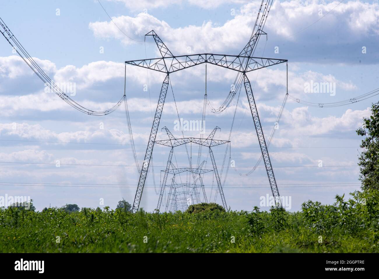 A view of power lines, electric power transmissions in a field in western Ukraine.Prime Minister of Ukraine, Denis Shmygal announced that from October 1st, the cost of electricity for 80% of the population will decrease following the Cabinet of Ministers passing a resolution which reduced the electricity tariff to UAH 1.44 per kilowatt/hour if households consume less than 250 kilowatt/hours per month. At the same time, if the household uses more than this norm, then all consumed electricity must be paid at full price - UAH 1.68 per kWh. Stock Photo