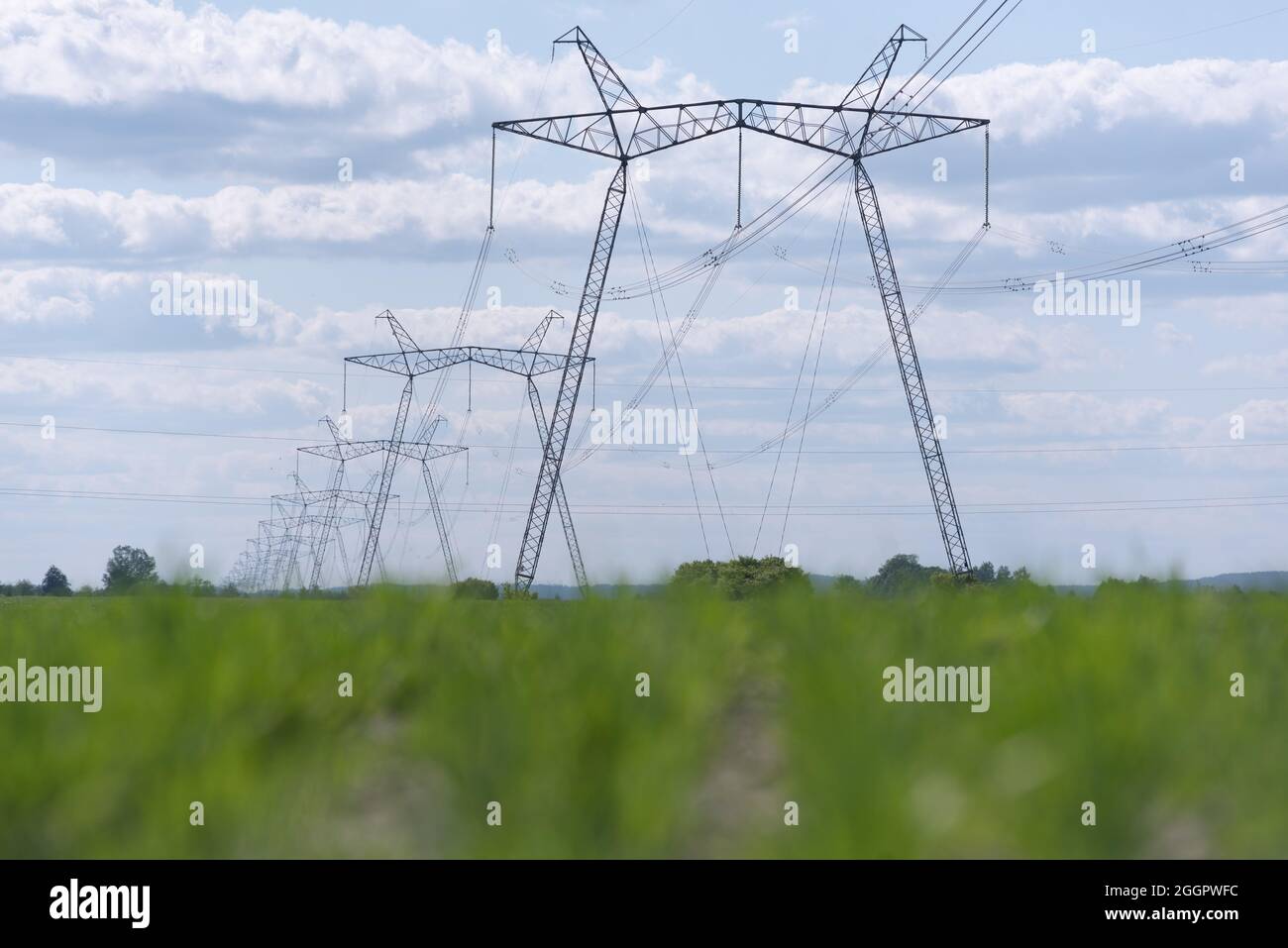 A view of power lines, electric power transmissions in a field in western Ukraine.Prime Minister of Ukraine, Denis Shmygal announced that from October 1st, the cost of electricity for 80% of the population will decrease following the Cabinet of Ministers passing a resolution which reduced the electricity tariff to UAH 1.44 per kilowatt/hour if households consume less than 250 kilowatt/hours per month. At the same time, if the household uses more than this norm, then all consumed electricity must be paid at full price - UAH 1.68 per kWh. (Photo by Mykola Tys/SOPA Images/Sipa USA) Stock Photo