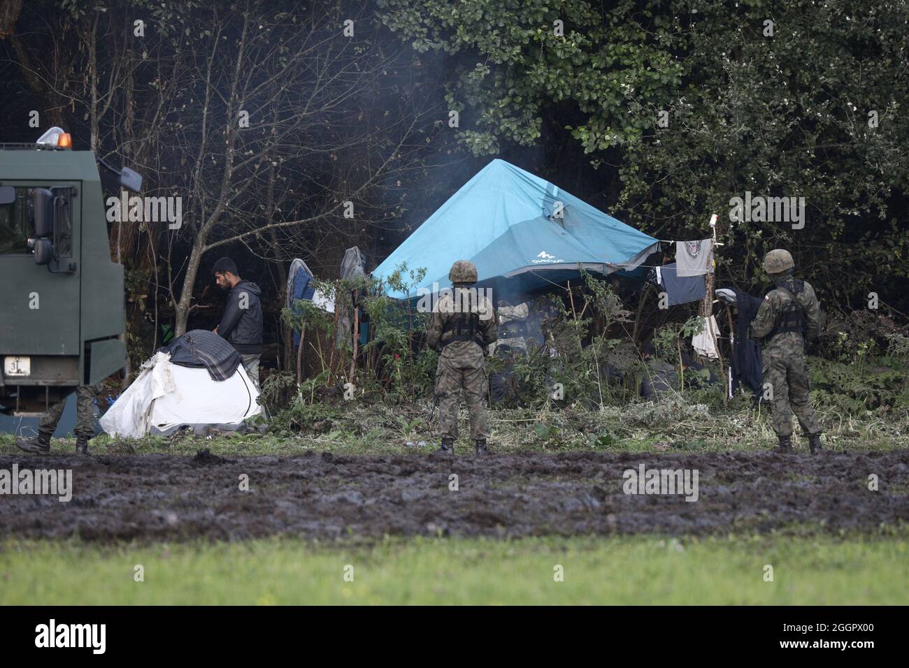 A small tent on the border with Belarus where several dozen Afghan migrants have been stuck is seen guarded by soldiers in Usnarz Gorny, Poland on August 31, 2021. On Thursday Polish president Andrzej Duda signed a law declaring a 30 day emergency sitation along the border with Belarus. As part of the emergency declaration no media will have access to some 200 localitites and no information on state activites relating to border security will be allowed to be disseminated. For more than three weeks a group of 32 migrants has been stuck on the border with Belarus, guarded by both Polish and Bela Stock Photo