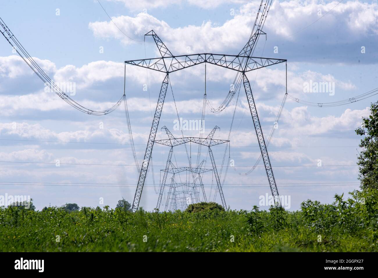 A view of power lines, electric power transmissions in a field in western Ukraine.Prime Minister of Ukraine, Denis Shmygal announced that from October 1st, the cost of electricity for 80% of the population will decrease following the Cabinet of Ministers passing a resolution which reduced the electricity tariff to UAH 1.44 per kilowatt/hour if households consume less than 250 kilowatt/hours per month. At the same time, if the household uses more than this norm, then all consumed electricity must be paid at full price - UAH 1.68 per kWh. (Photo by Mykola Tys/SOPA Images/Sipa USA) Stock Photo