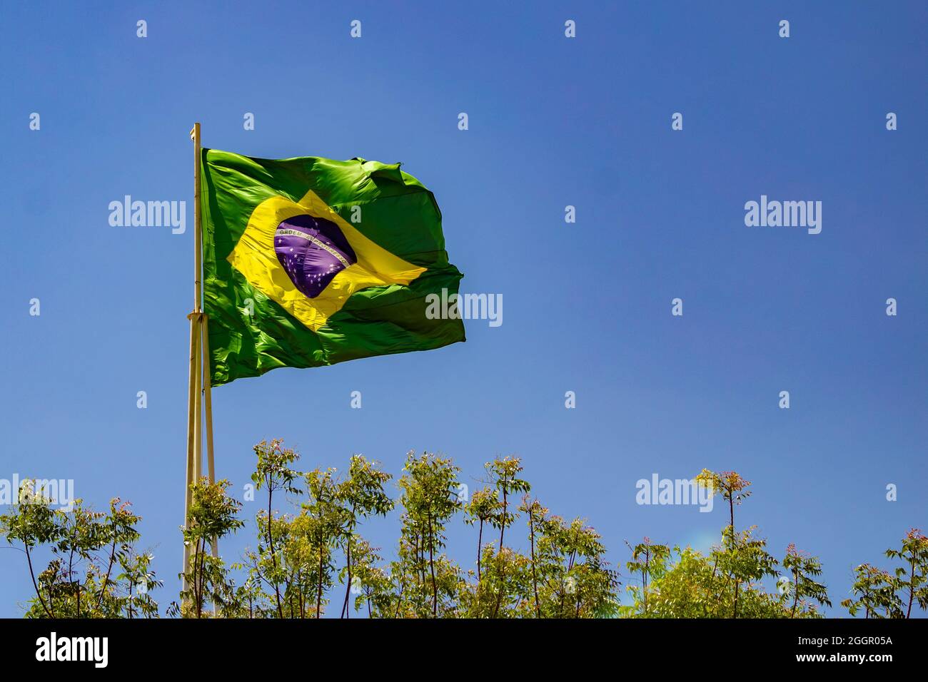 Brazil's flag ; The Brazilian flag flying on the mast with blue sky in the background. Stock Photo