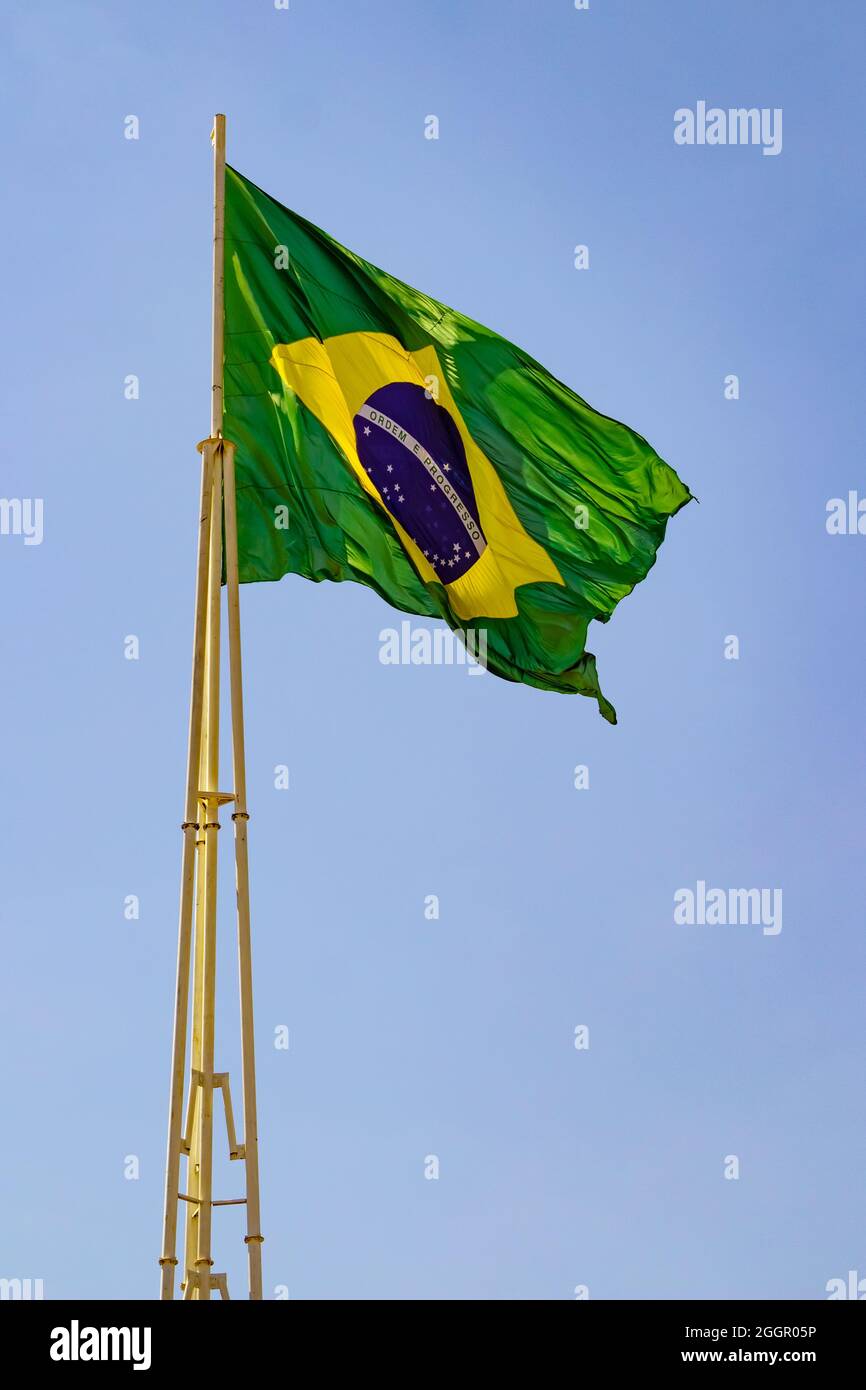 Brazil's flag ; The Brazilian flag flying on the mast with blue sky in the background. Stock Photo