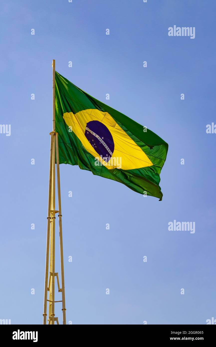 Brazil's flag ; The Brazilian flag flying on the mast with blue sky in the background. Stock Photo