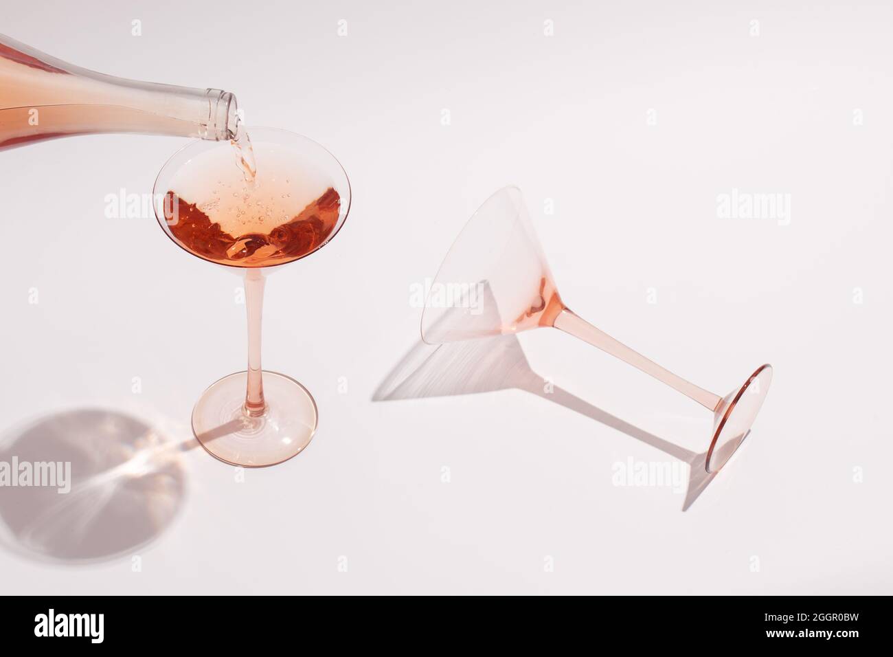Pouring Rose wine in cocktail rose glass on white background Stock ...
