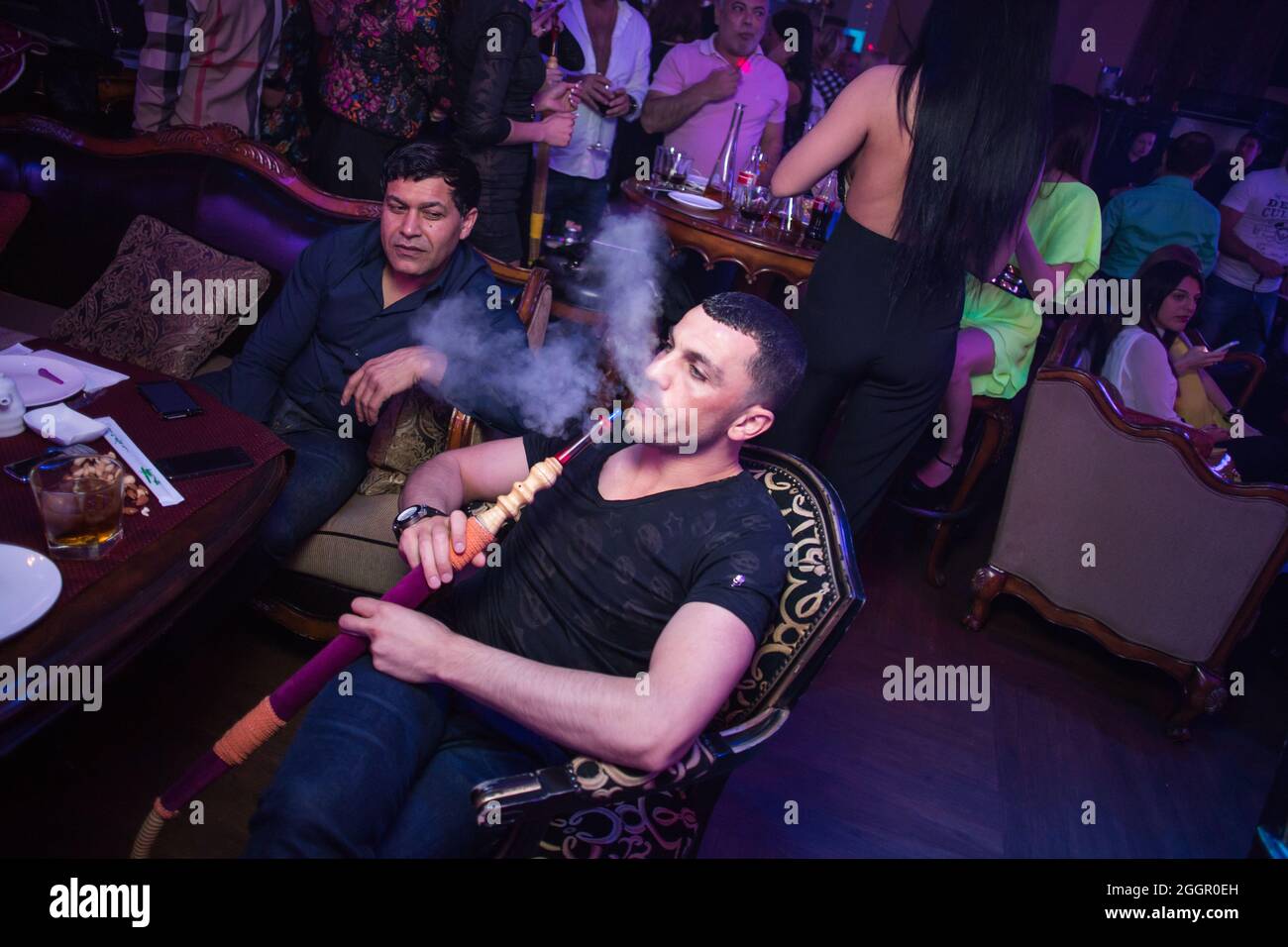 Odessa, Ukraine April 26, 2014: Ministerium night club. People smoking hookah during concert in night club party. Man and woman have fun at club Stock Photo