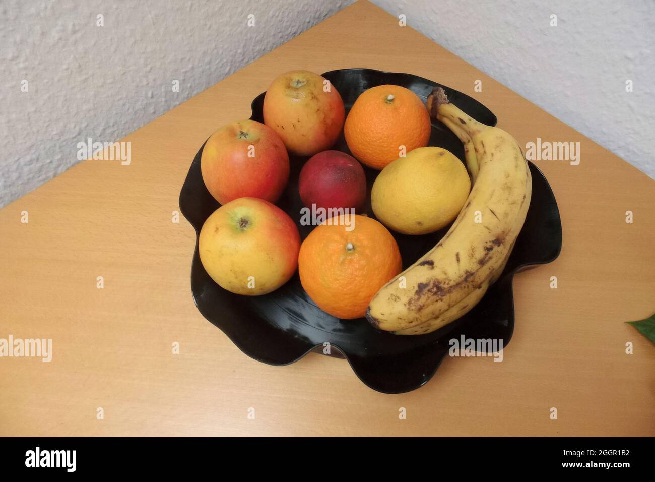 Essen verschidene Früchte auf einen schwarzen Teller Stock Photo