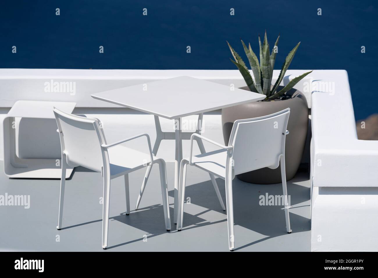 White table and chairs on terrace in Oia, Santorini. Stock Photo