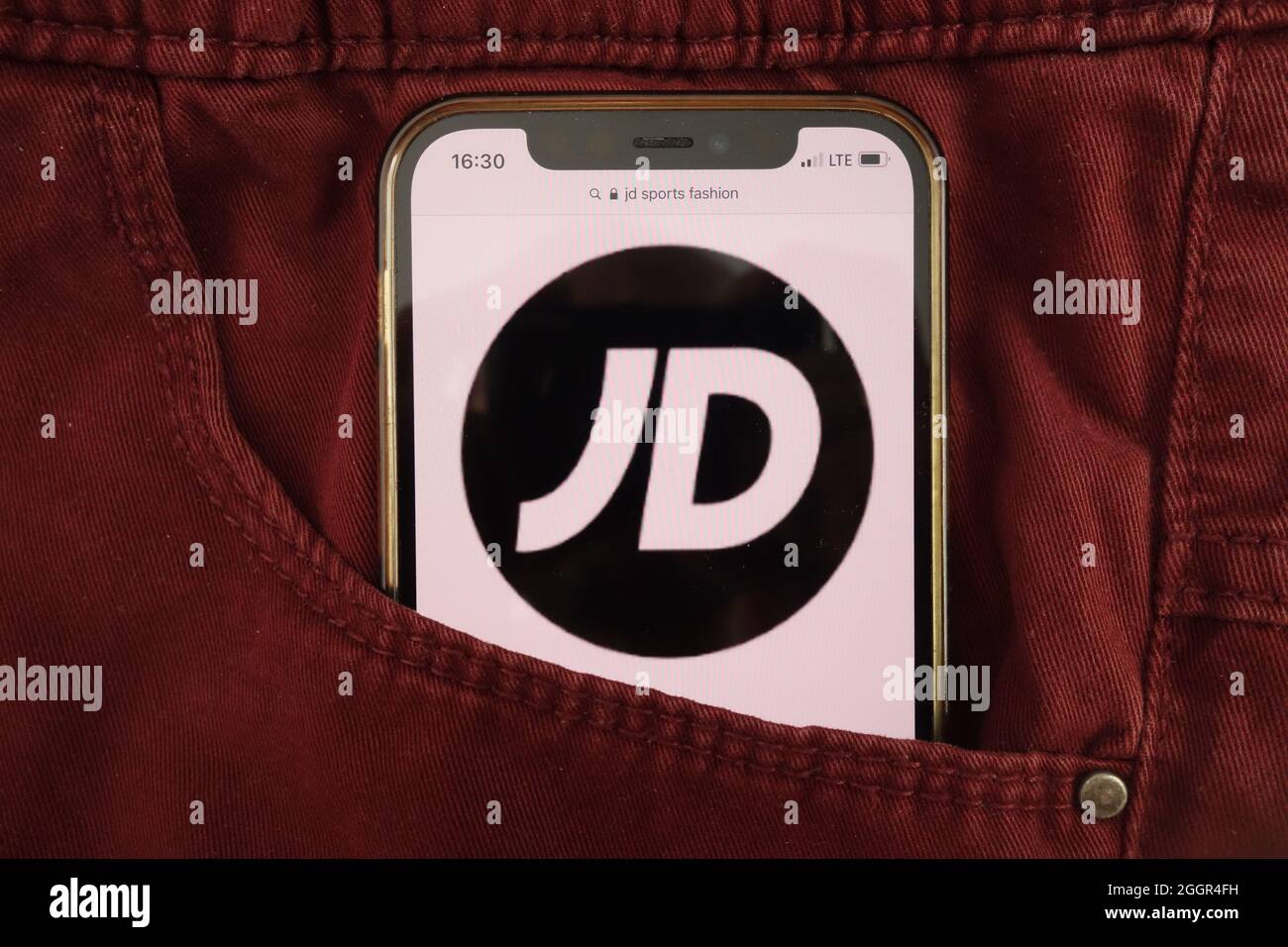 KONSKIE, POLAND - August 17, 2021: JD Sports Fashion plc logo displayed on mobile phone hidden in jeans pocket Stock Photo