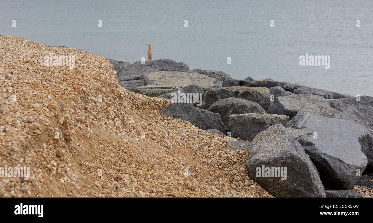 Medmerry, West-Sussex, UK. 29th August 2021. Medmerry has a long history of low-level erosion of its coast caused by waves. Here we can see the combination of rocks and gravel giving protection against wave erosion. Credit: Joe Kuis / Alamy reportage Stock Photo