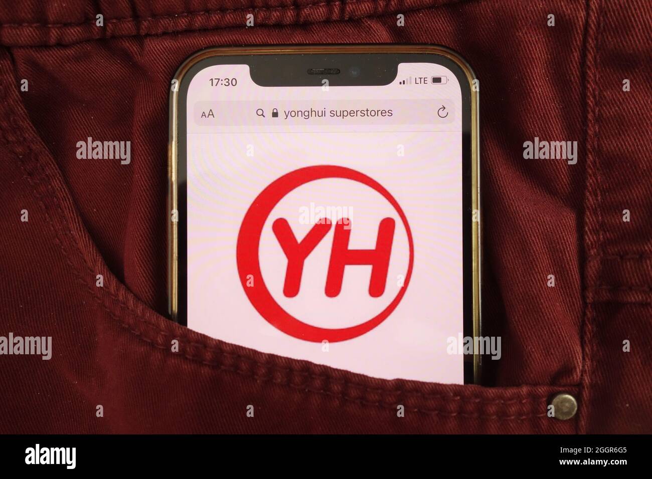 KONSKIE, POLAND - August 17, 2021: Yonghui Superstores logo displayed on mobile phone hidden in jeans pocket Stock Photo
