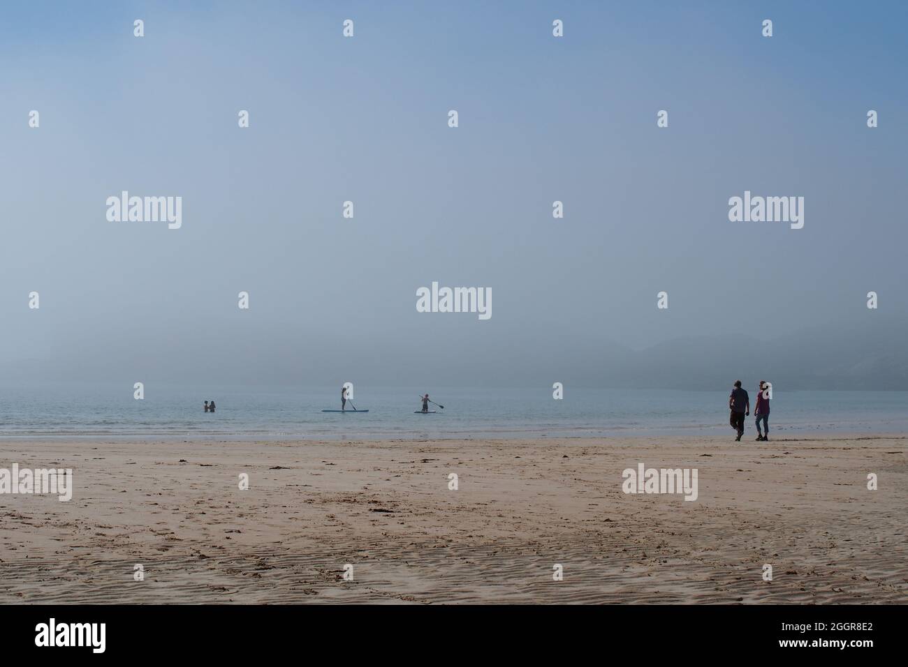 People enjoying the sea and beach on a staycation in Oldshoremore, Kinlochbervie, northwest Scotland, as a sea mist sweeps in over the beach Stock Photo