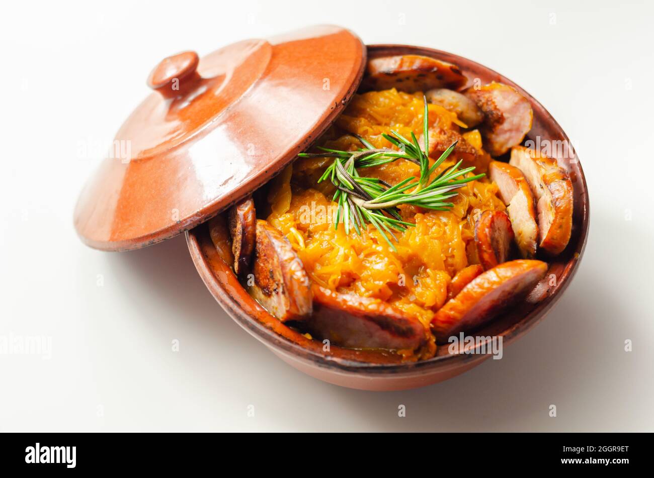 Traditional Polish dish called bigos made of sauerkraut, sausage and mushrooms, food served warm in a ceramic bowl, Eastern European food Stock Photo