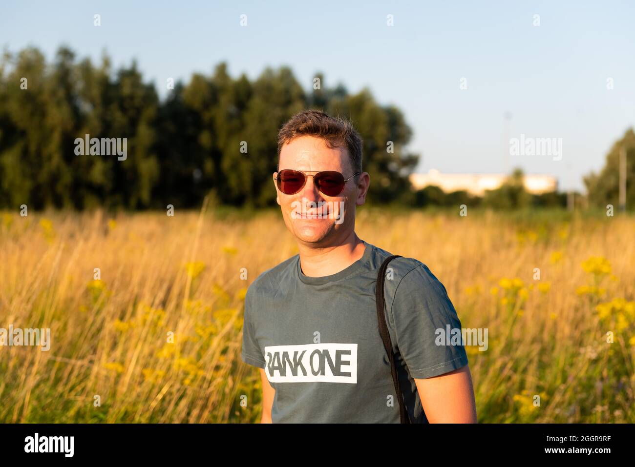 Ghent, East Flanders Region, Belgium - 07 18 2021: Portrait of an attractive sporty forty year old man with sunglasses and a natural background Stock Photo