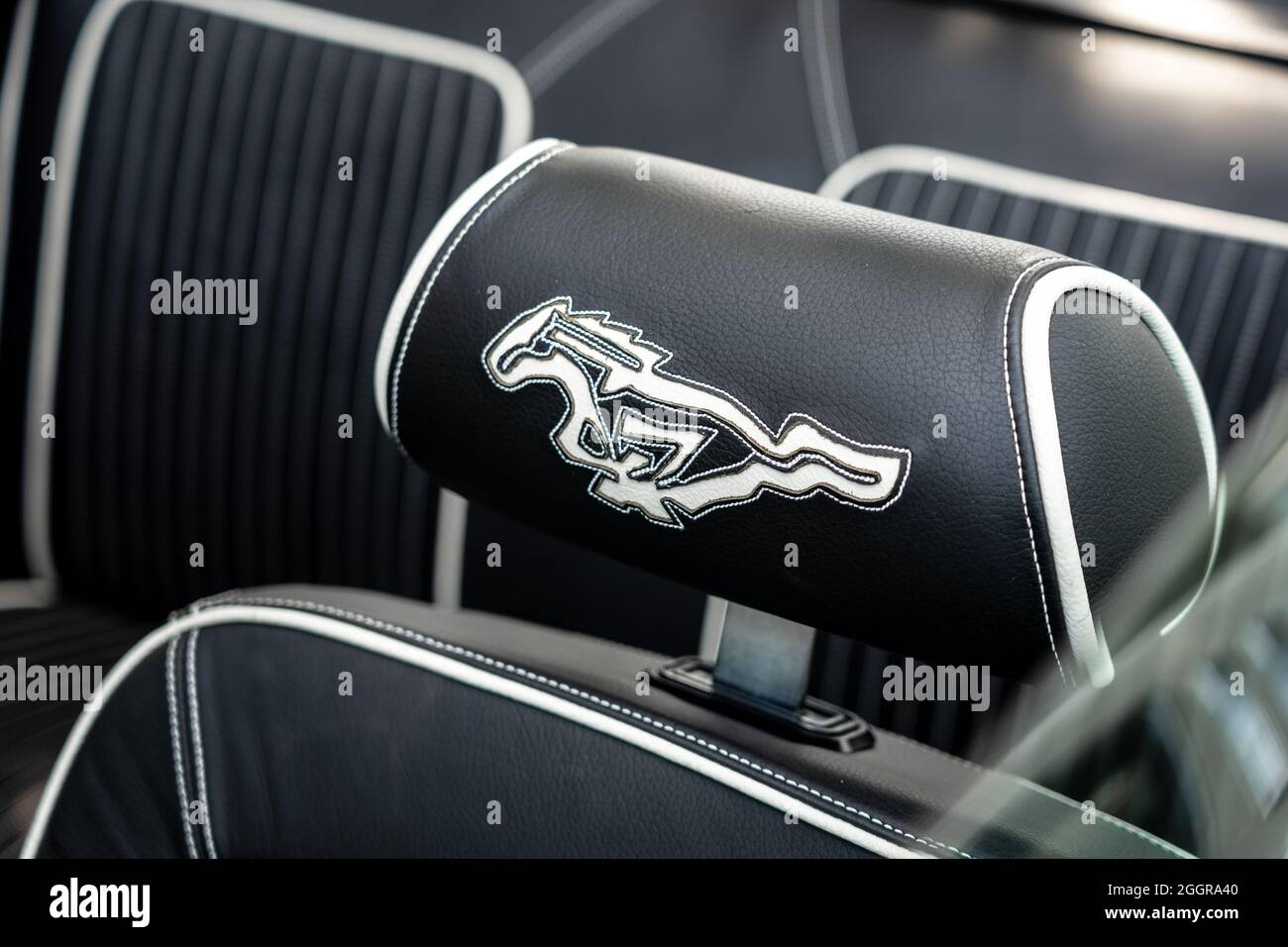 The interior of sports car Ford Mustang. Embroidery (Mustang) on the leather headrest. The exhibition of 'US Car Classics'. Stock Photo