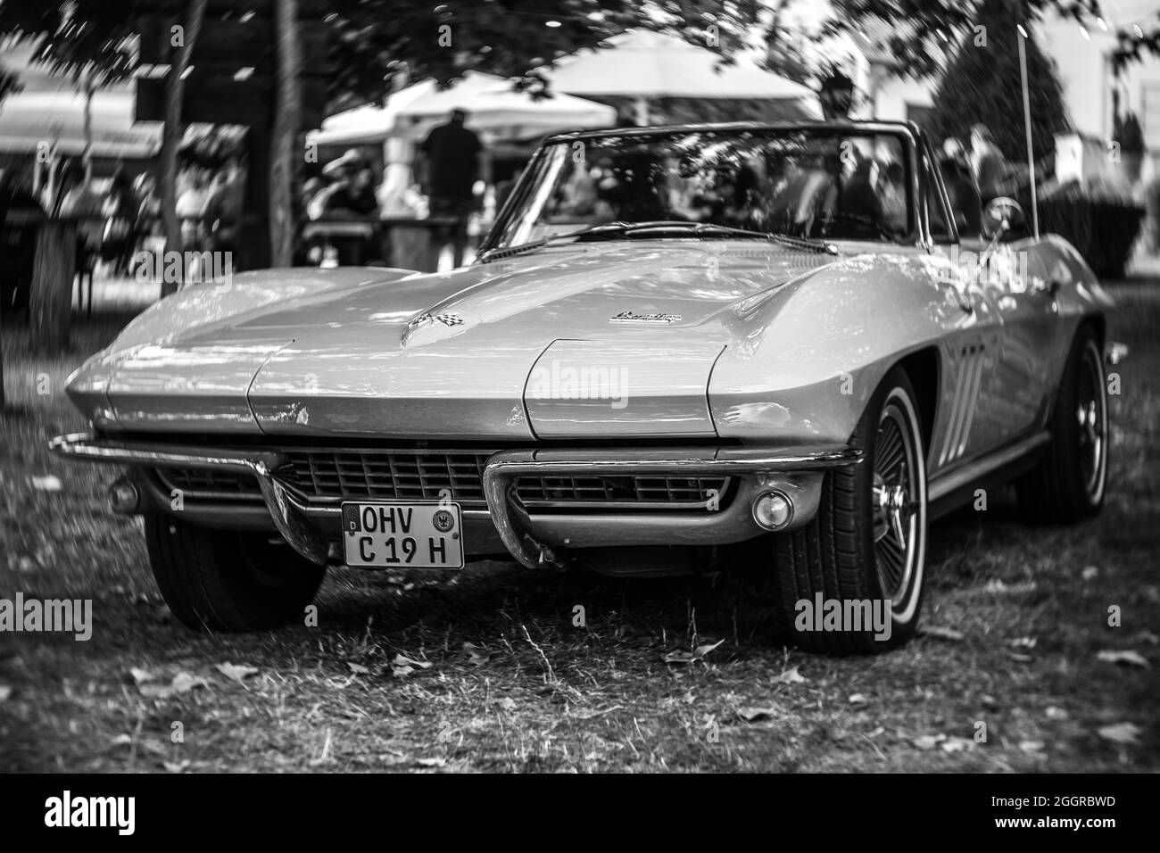 The sports car Chevrolet Corvette Sting Ray Convertible (C2). Focus on center. Swirly bokeh. Black and white. The exhibition of 'US Car Classics'. Stock Photo