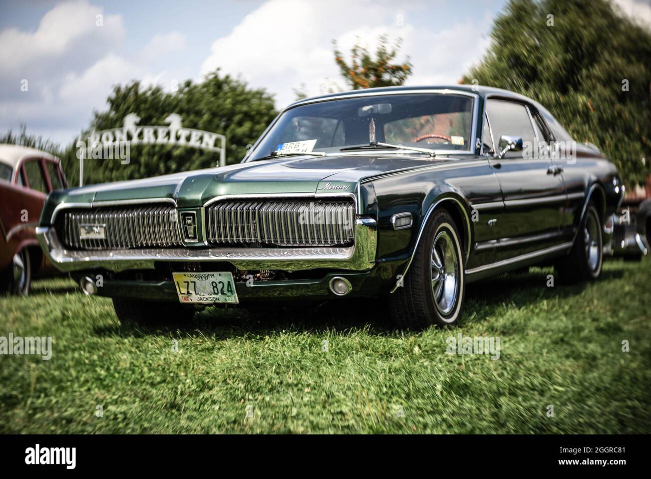 DIEDERSDORF, GERMANY - AUGUST 21, 2021: The pony car Mercury Cougar GT, 1967. Focus on center. Swirly bokeh. The exhibition of 'US Car Classics'. Stock Photo
