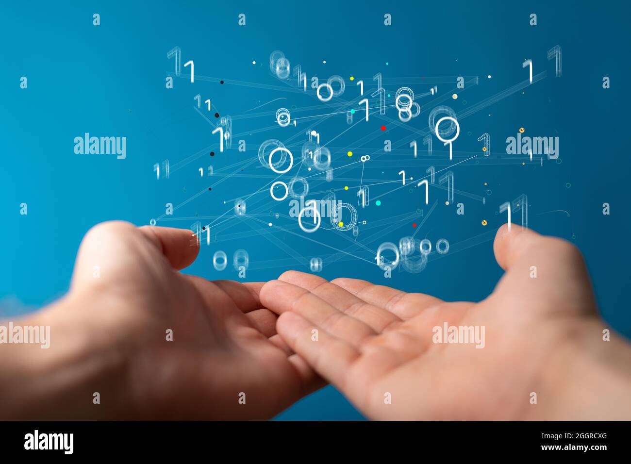 Floating virtual intelligence connections above hands on a blue background Stock Photo