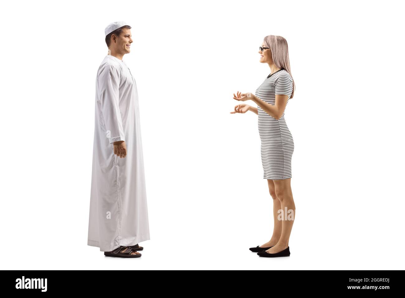Full length profile shot of a woman talking to a young man in ethnic clothes isolated on white background Stock Photo