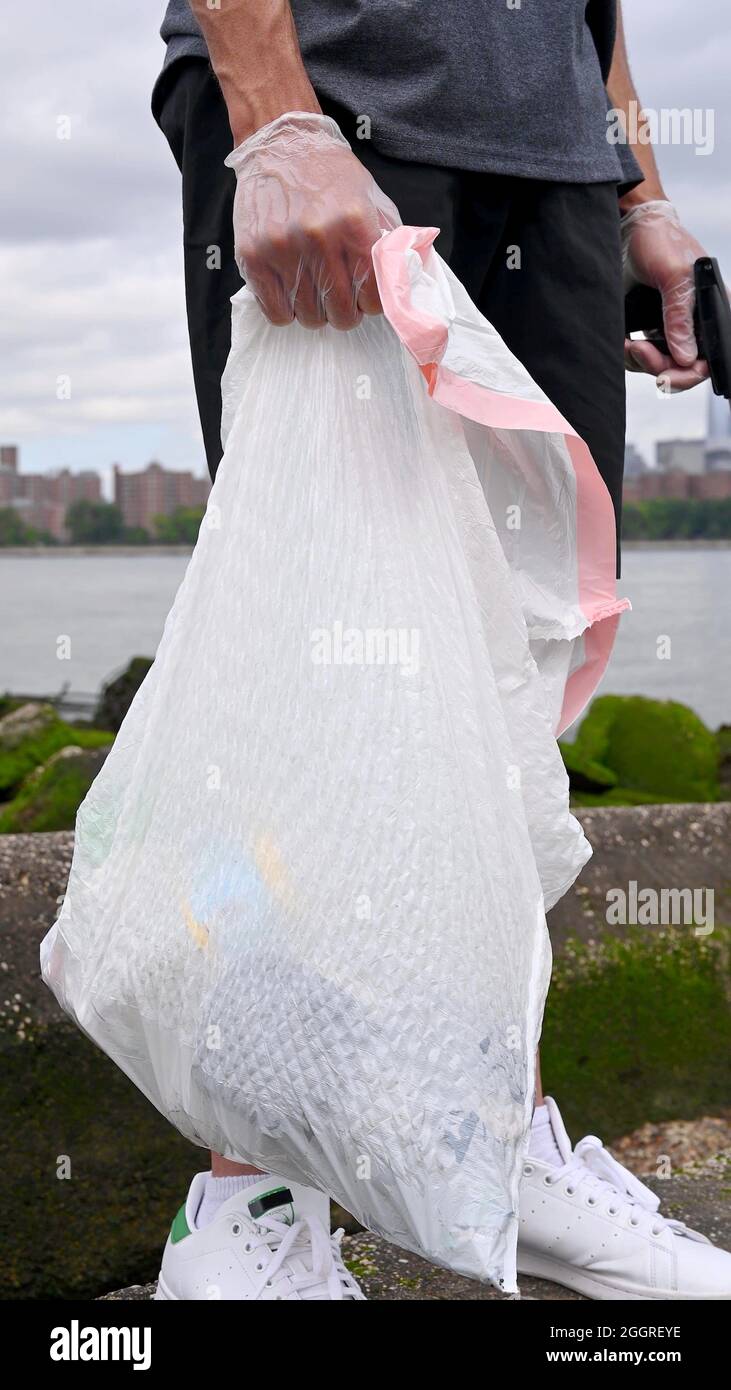 A garbage bag in the hand of a man Stock Photo