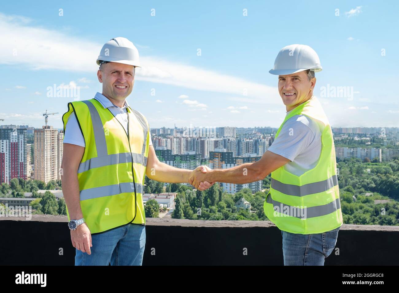 Architect and civil engineer shaking hands on the construction site ...