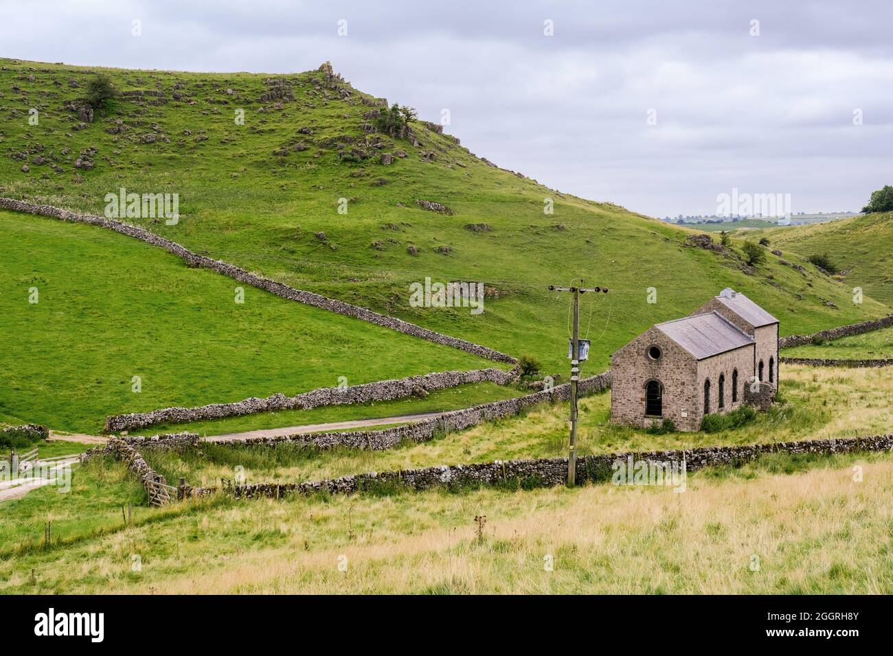 A distant view of Roystone Grange Pump House, a 19th century building which pumped compressed air to drive drills in the local quarries. Limestone wal Stock Photo