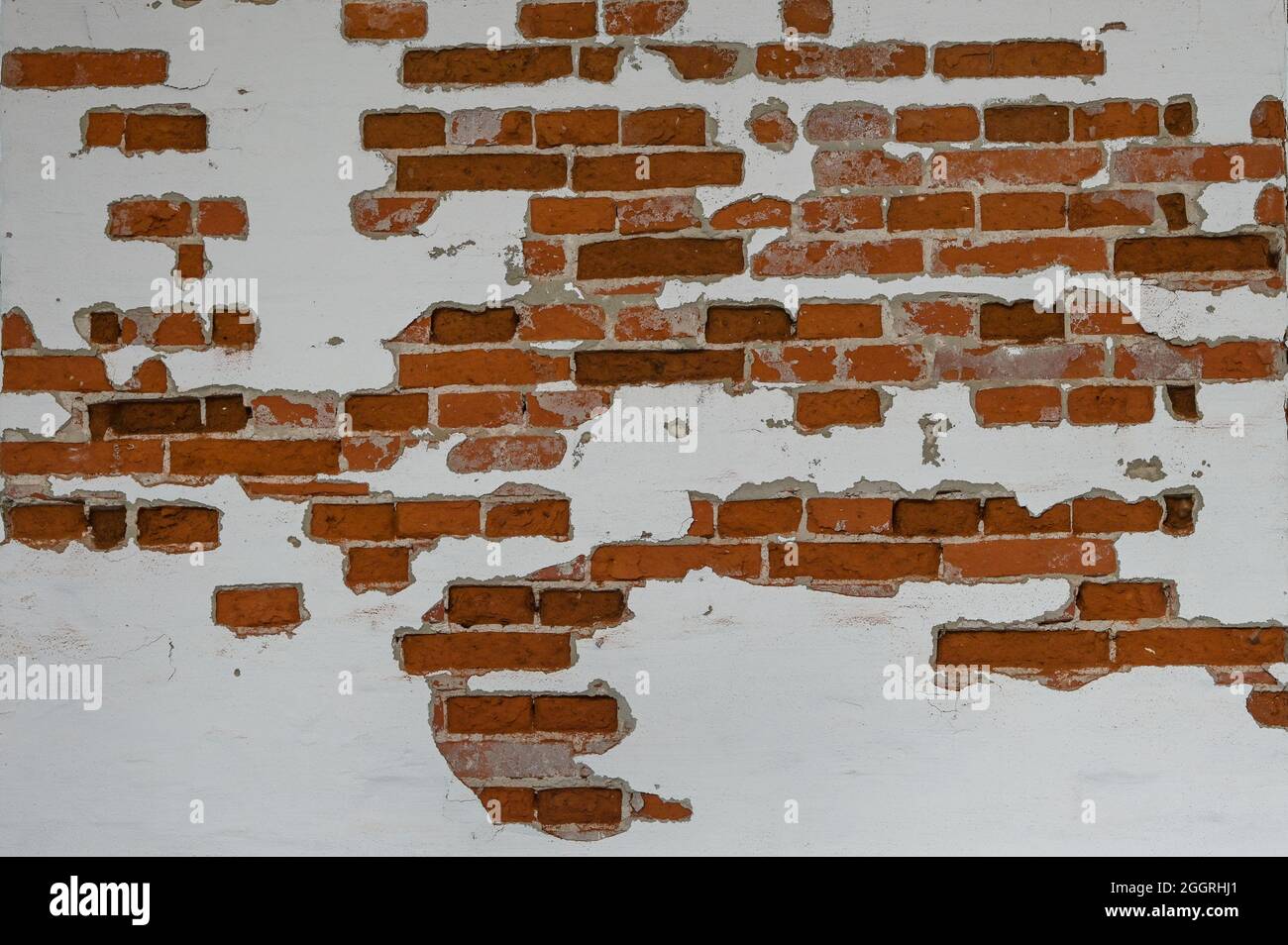 Old red brick wall partially plastered and white painted, background texture for historical architecture concepts, copy space, selected focus Stock Photo