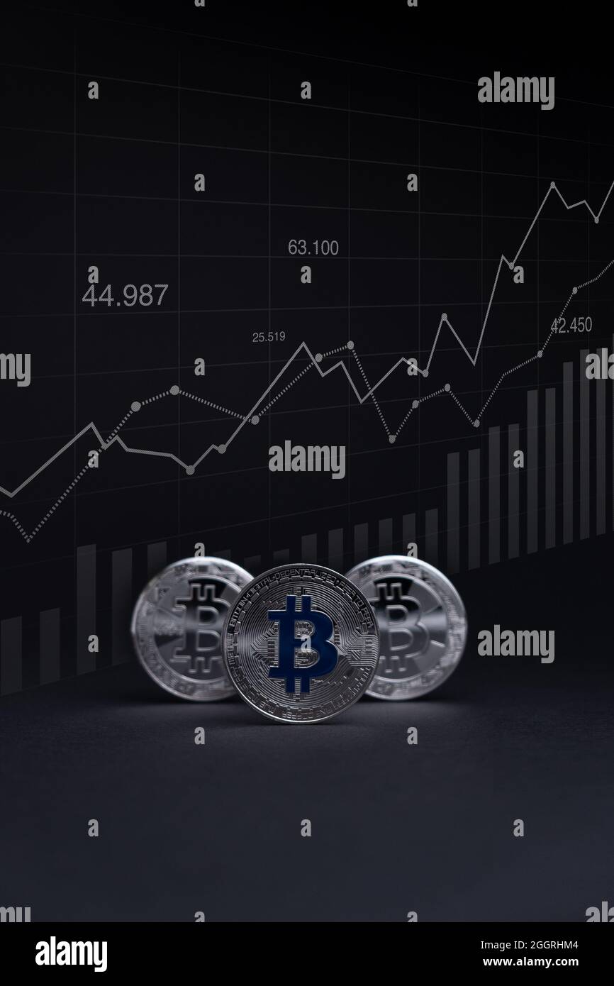 Silver Bitcoin coins currency. Crypto coin with growth chart, on a dark background. BTC International stock exchange. Stock Photo